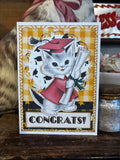 Graduation-themed card with a vintage cat in a redish cap and gown holding a diploma.