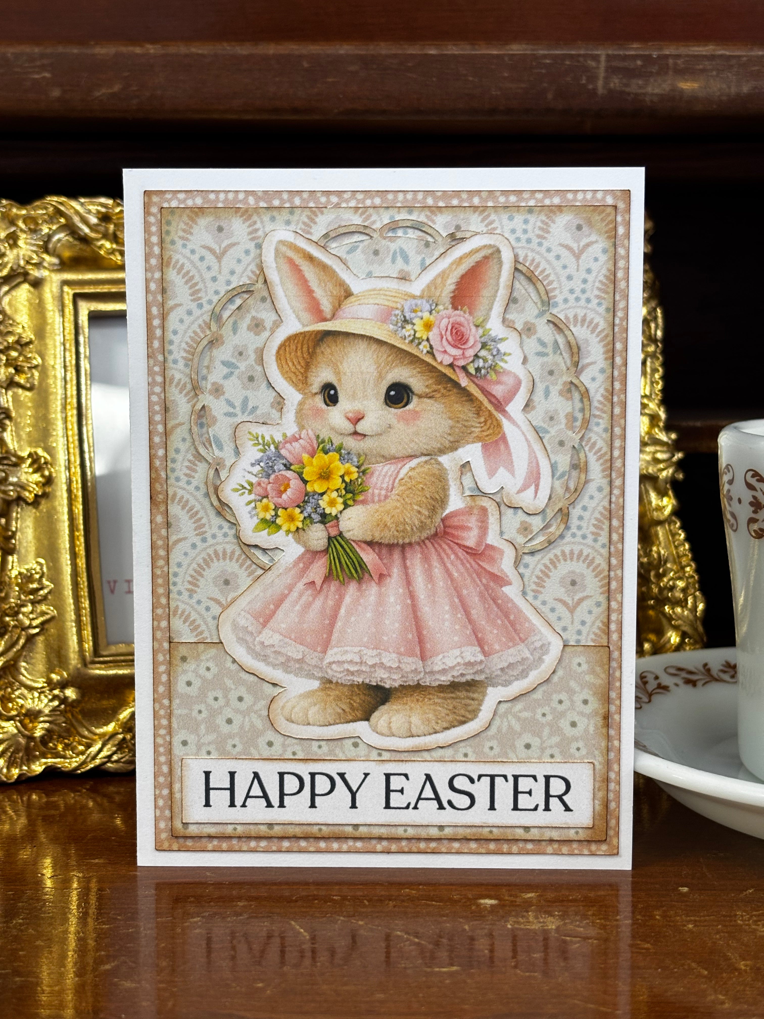 Easter card with a bunny in a dress and bonnet holding flowers with the text "Happy Easter"