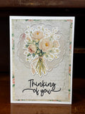 A greeting card with a floral design and 'Thinking of you' text on it.