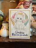 Memorial card with a cat with angel wings and a halo illustration, and the text 'Sometimes there are no words'. 