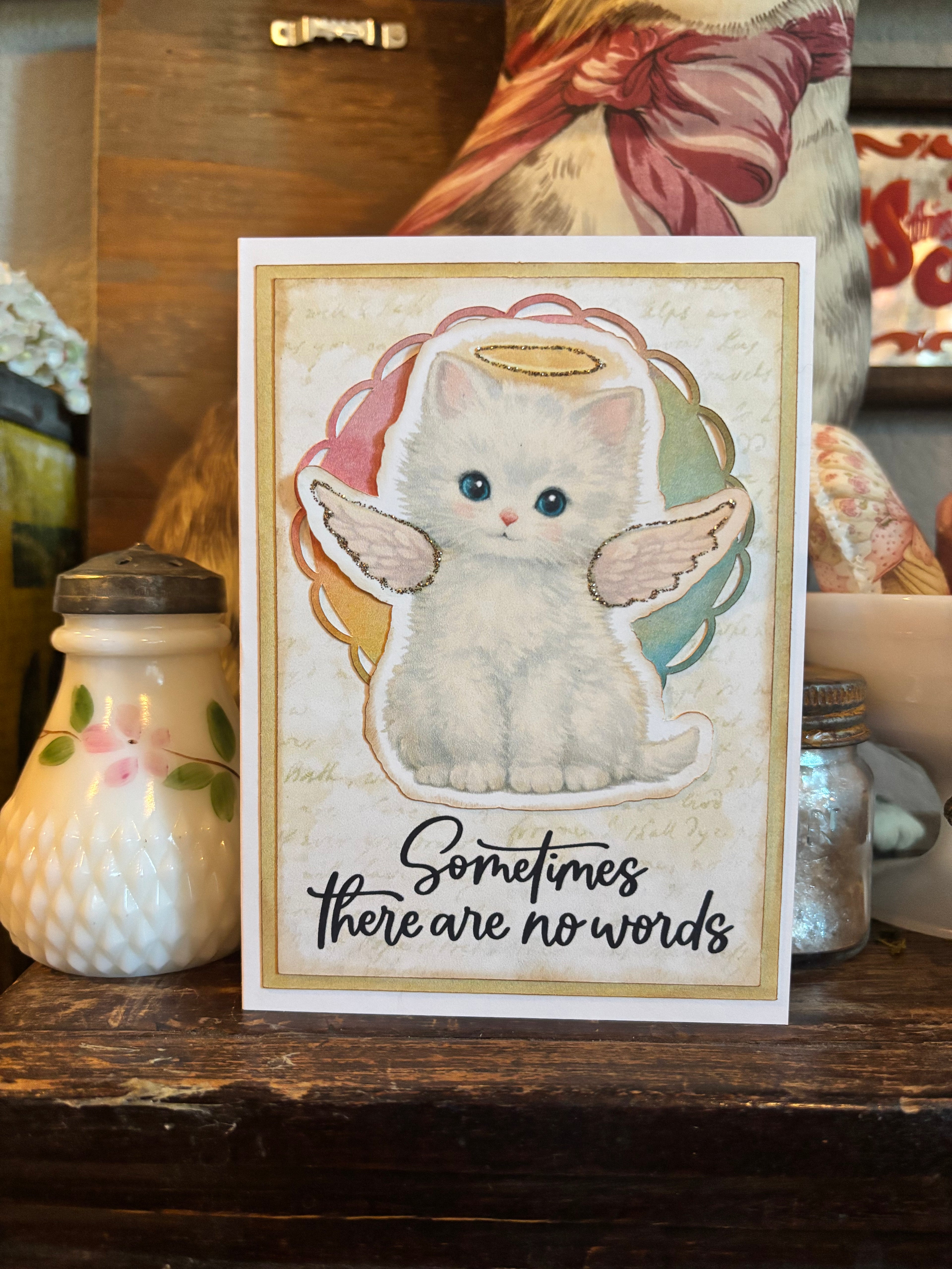 Memorial card with a cat with angel wings and a halo illustration, and the text 'Sometimes there are no words'. 